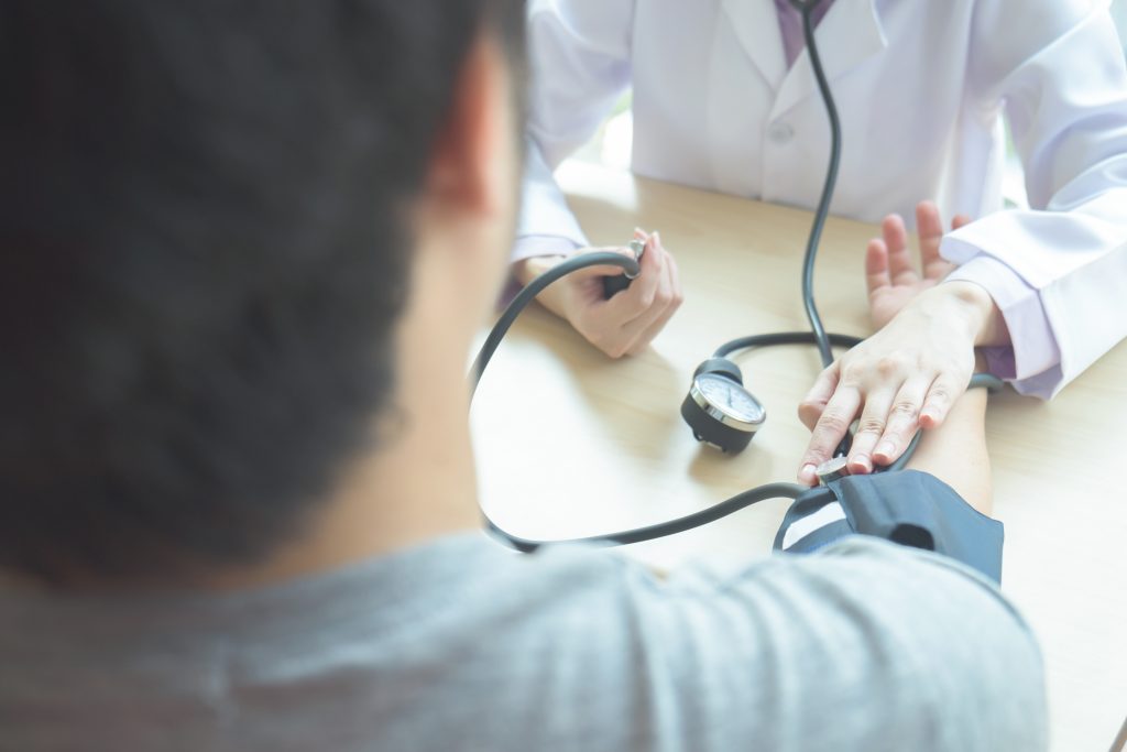 doctor checking a man's blood pressure