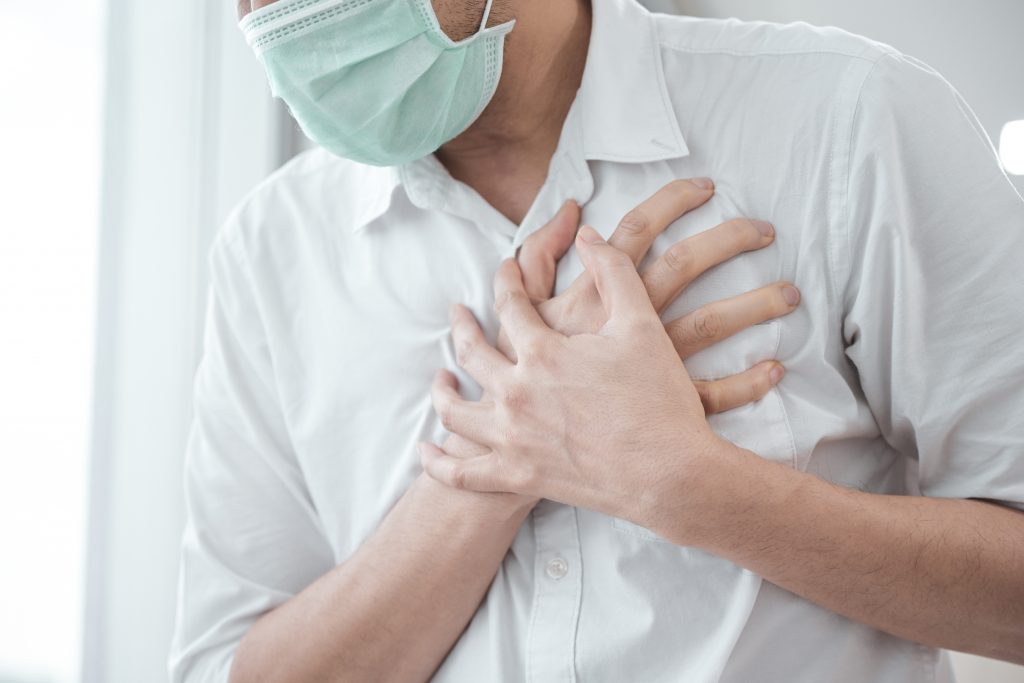 man wearing a mask having a heart attack